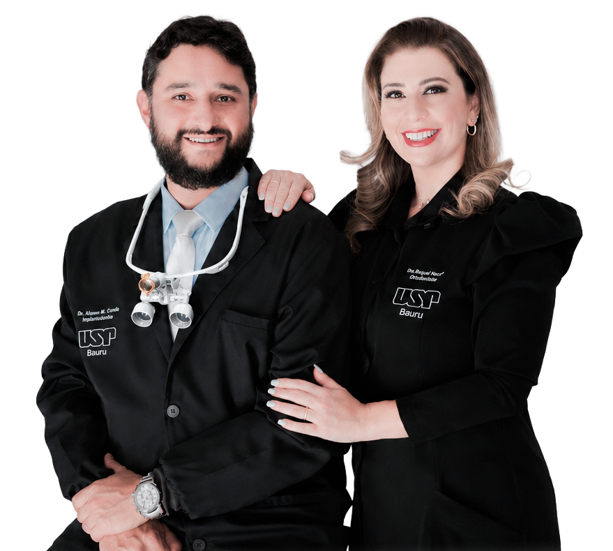 Dr. Alysson e Dra. Raquel, dentistas especialistas da Clínica Dom Odontologia, sorrindo e vestindo jalecos pretos profissionais.